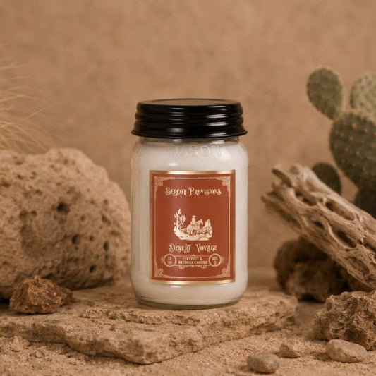 Jar of candle with desert-themed label on a sandy background