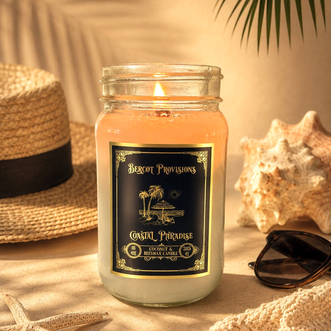Candle in a glass jar with a label, surrounded by beach-themed decor including a hat, sunglasses, and shells.