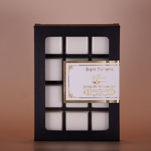 Set of white wax melts in a black box with a visible brand label on a brown background