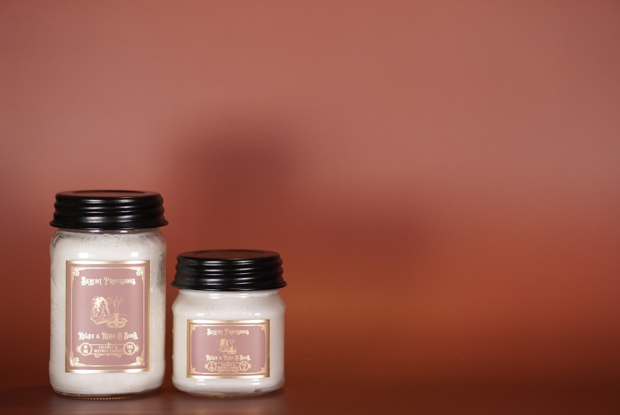 Two candles with labels on a brown background