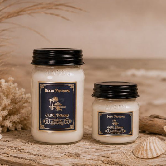 Two candles with labels on a wooden surface with natural elements.