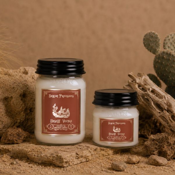 Two candles with labels on a natural background with cacti