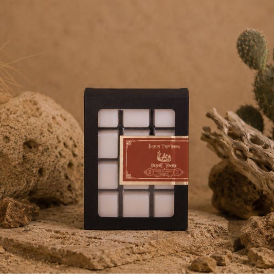 Box of white candles with a red label on a textured surface with natural elements.